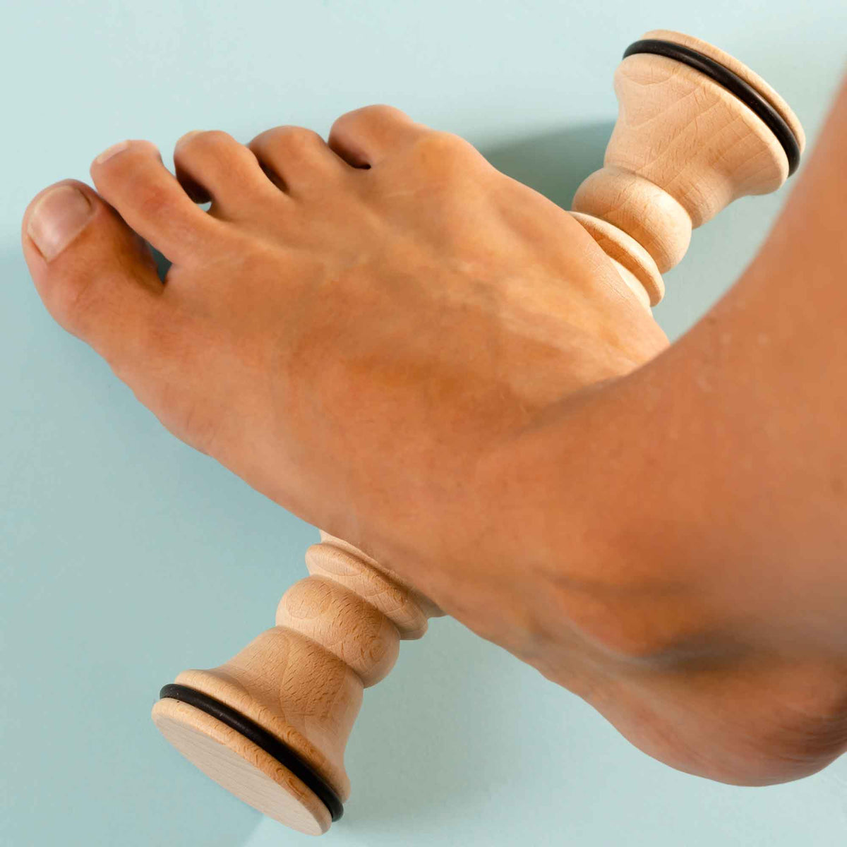 Wooden foot roller stick used for gentle self-massage on the foot