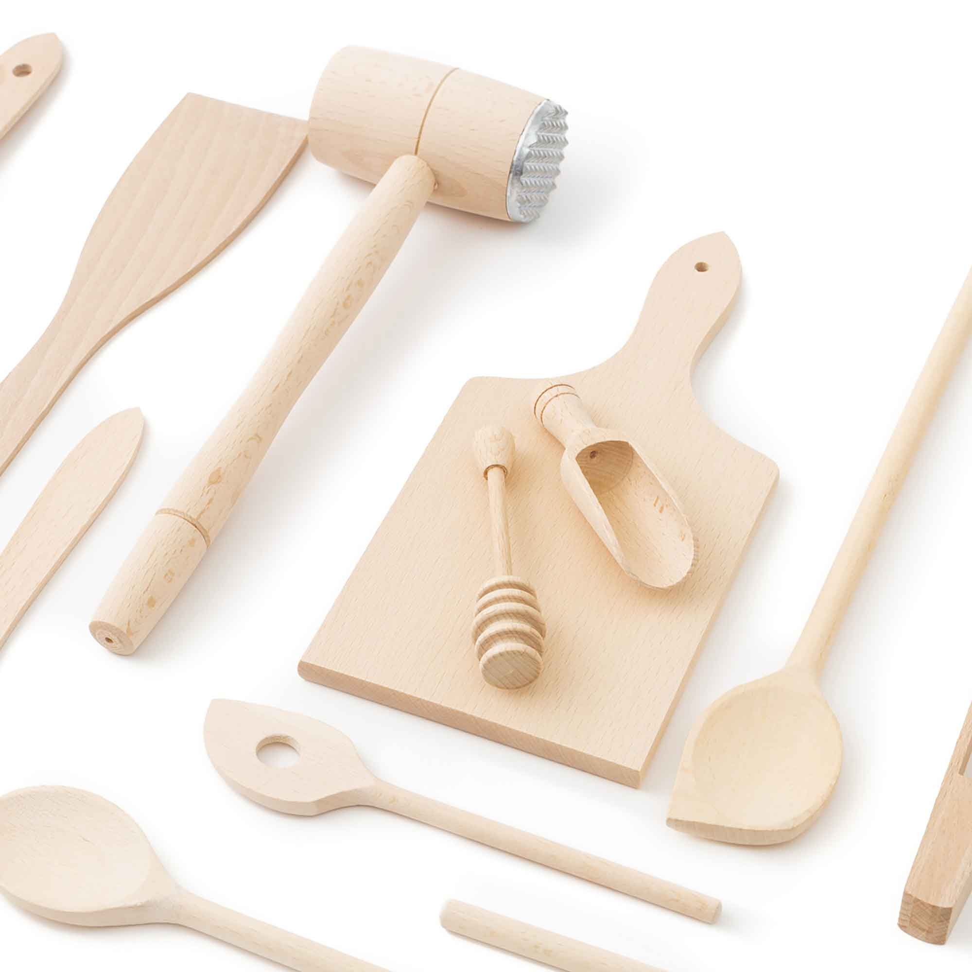 Wooden kitchen utensils and cooking tools arranged on a light background