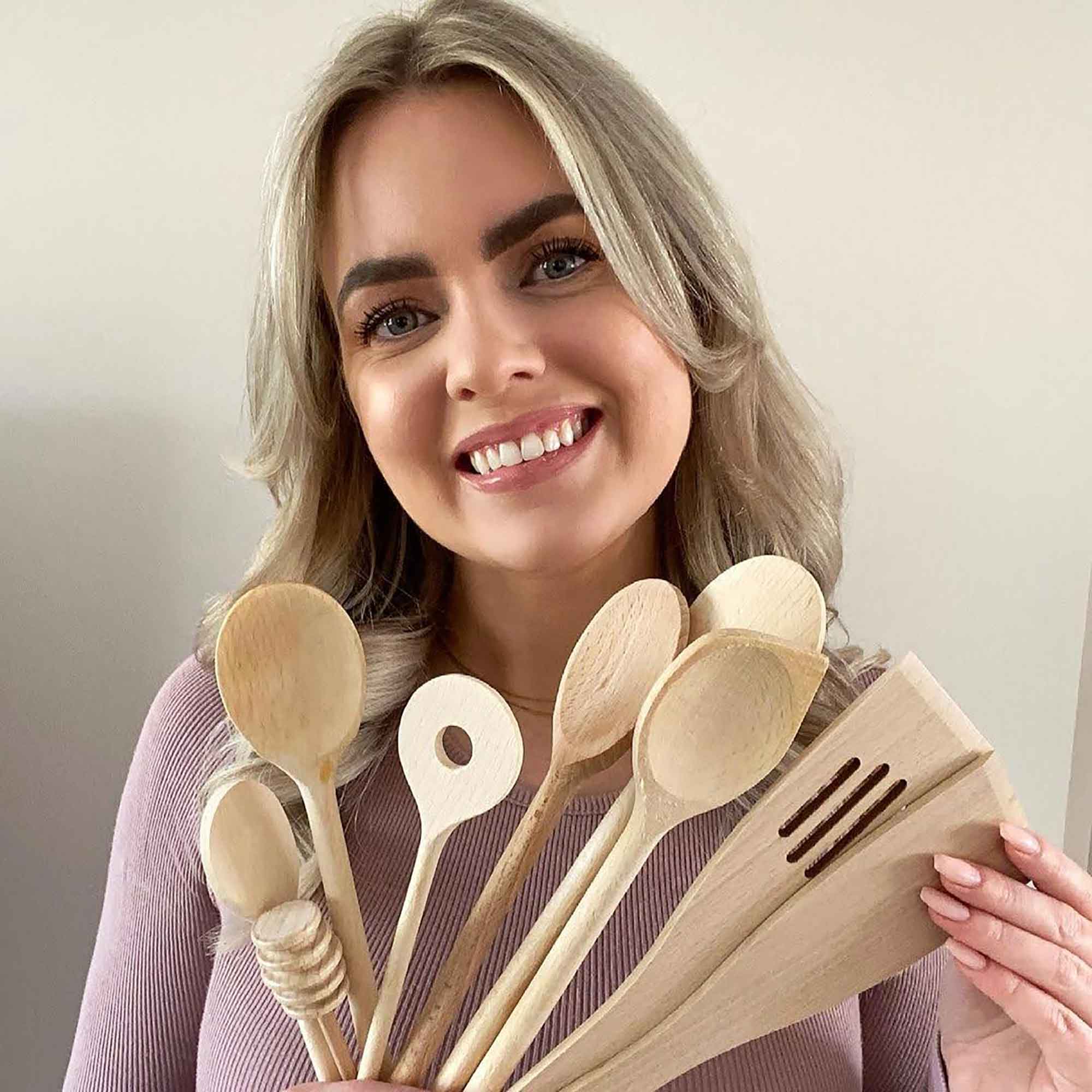 Person holding a selection of wooden kitchen utensils for product inspiration