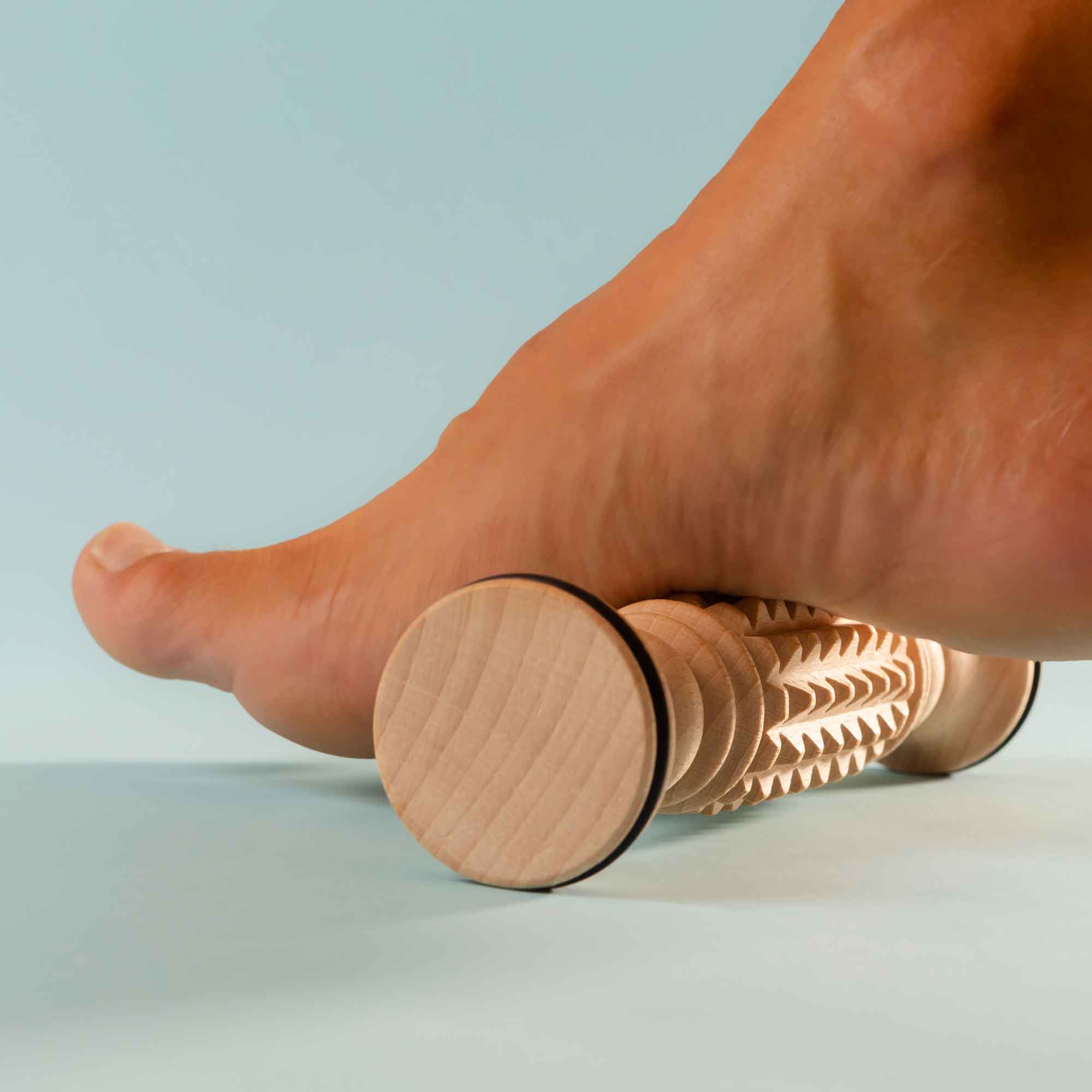 Wooden massage roller used on the leg as part of an appearance-focused self-care routine