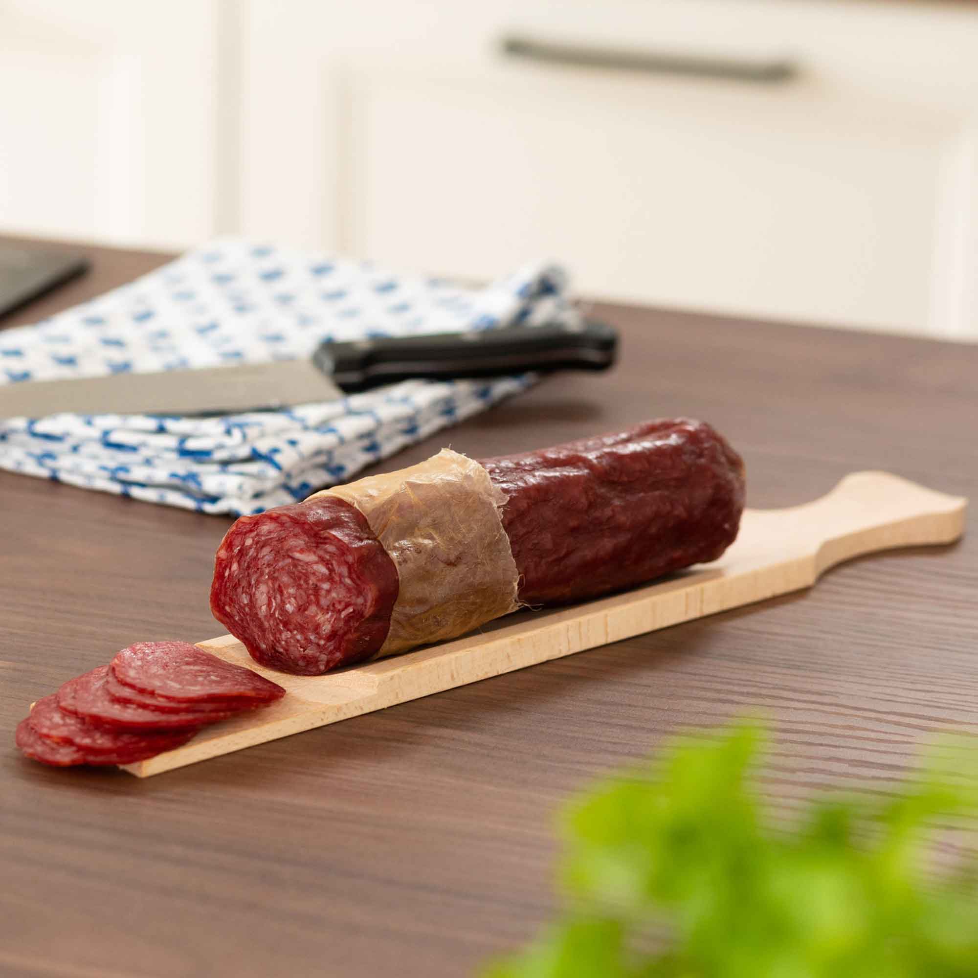 Wooden serving board and kitchen paddle shown in a food preparation setting