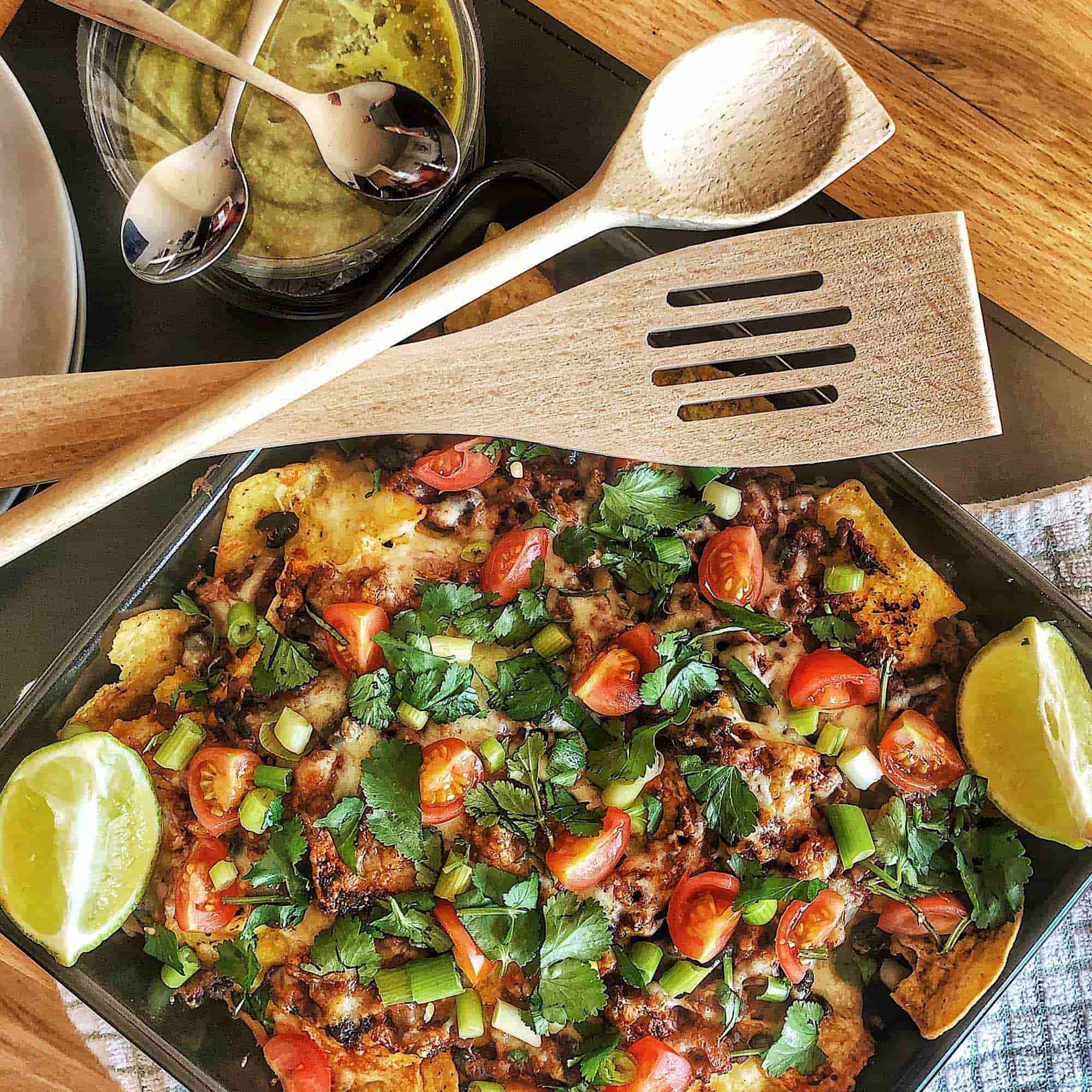 Wooden spatula and kitchen utensils beside a prepared meal for everyday cooking