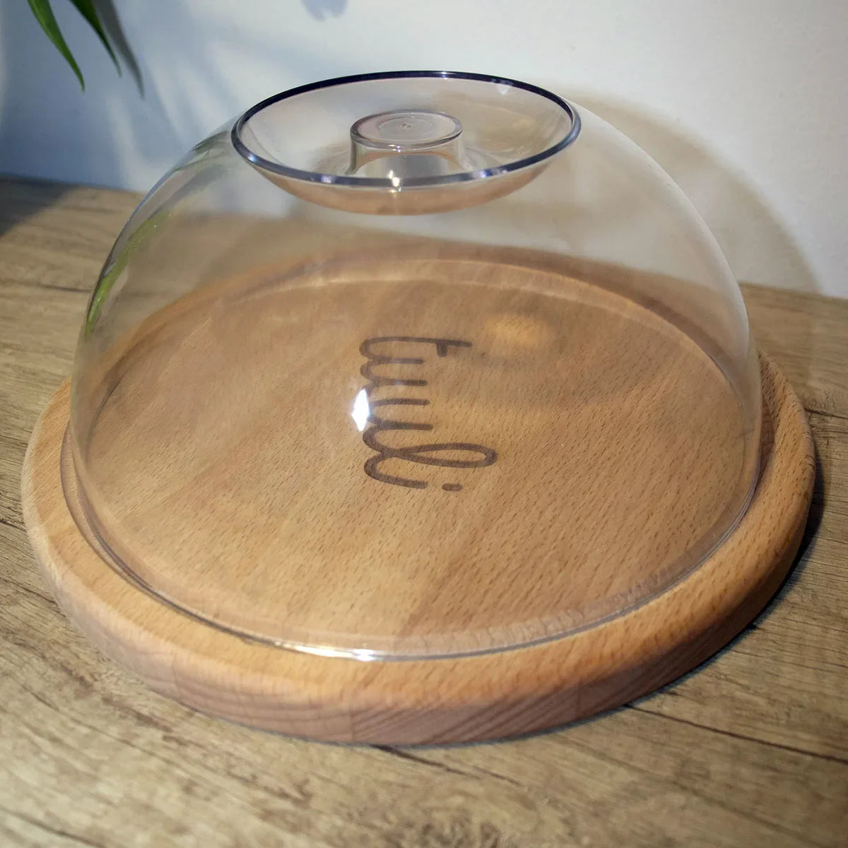 Rond houten snijplank met deksel met ambachtelijke kazen en fruit