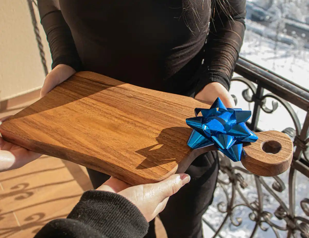 Engraved wooden cutting boards and kitchen tools arranged as personalized gift ideas