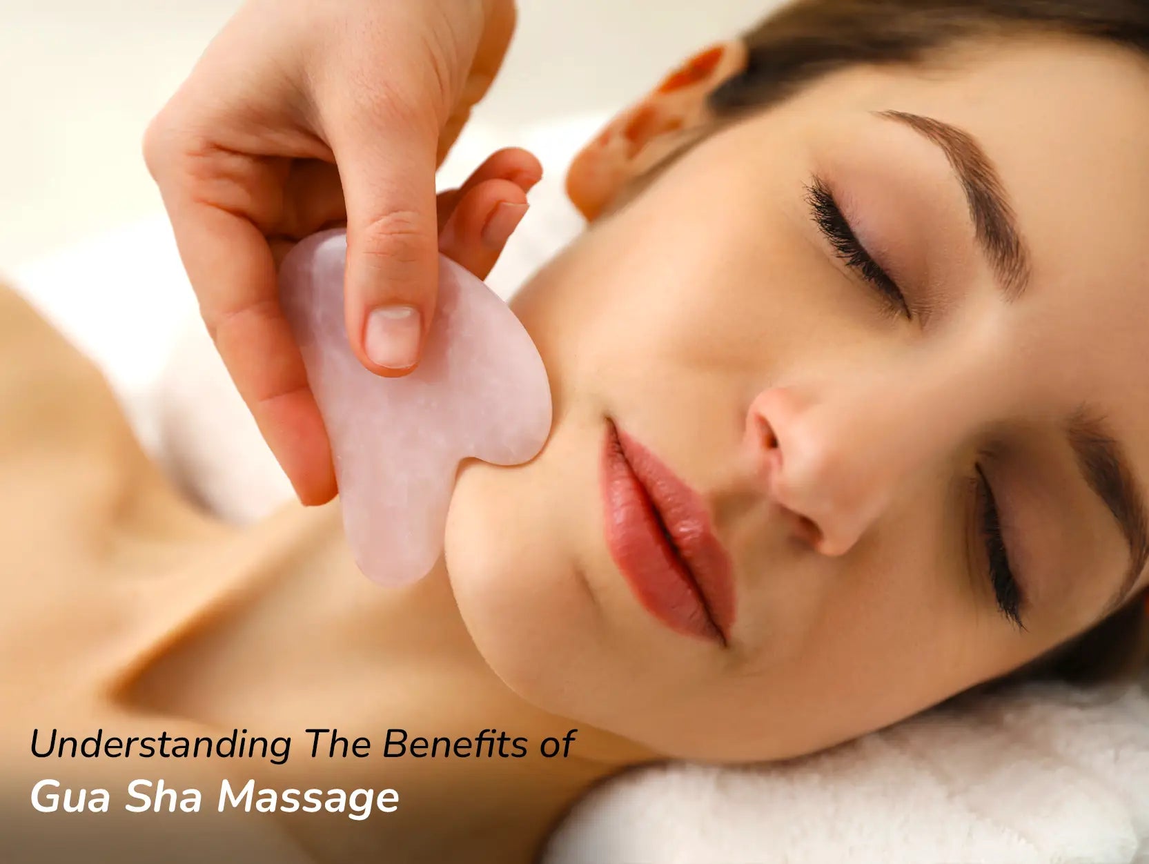 girl lying closing her eyes and taking massage from gua sha tool