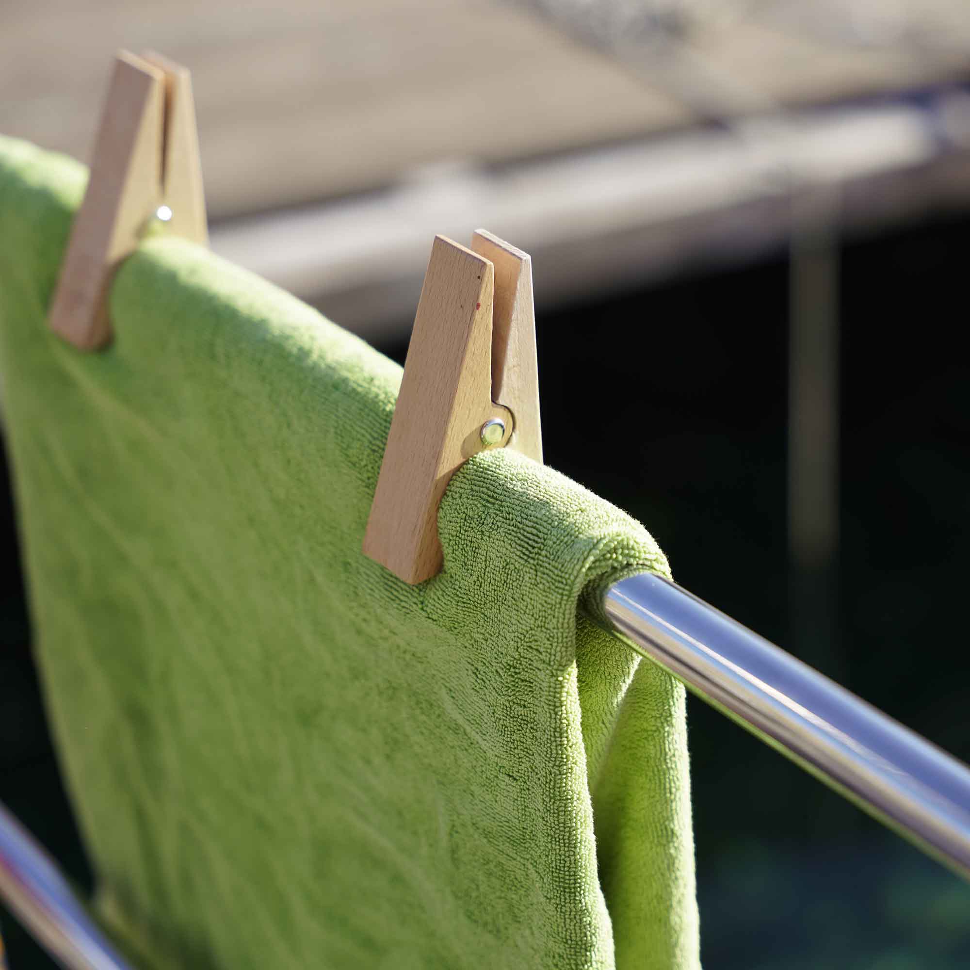 Wooden beach towel clips holding a towel securely on a rail