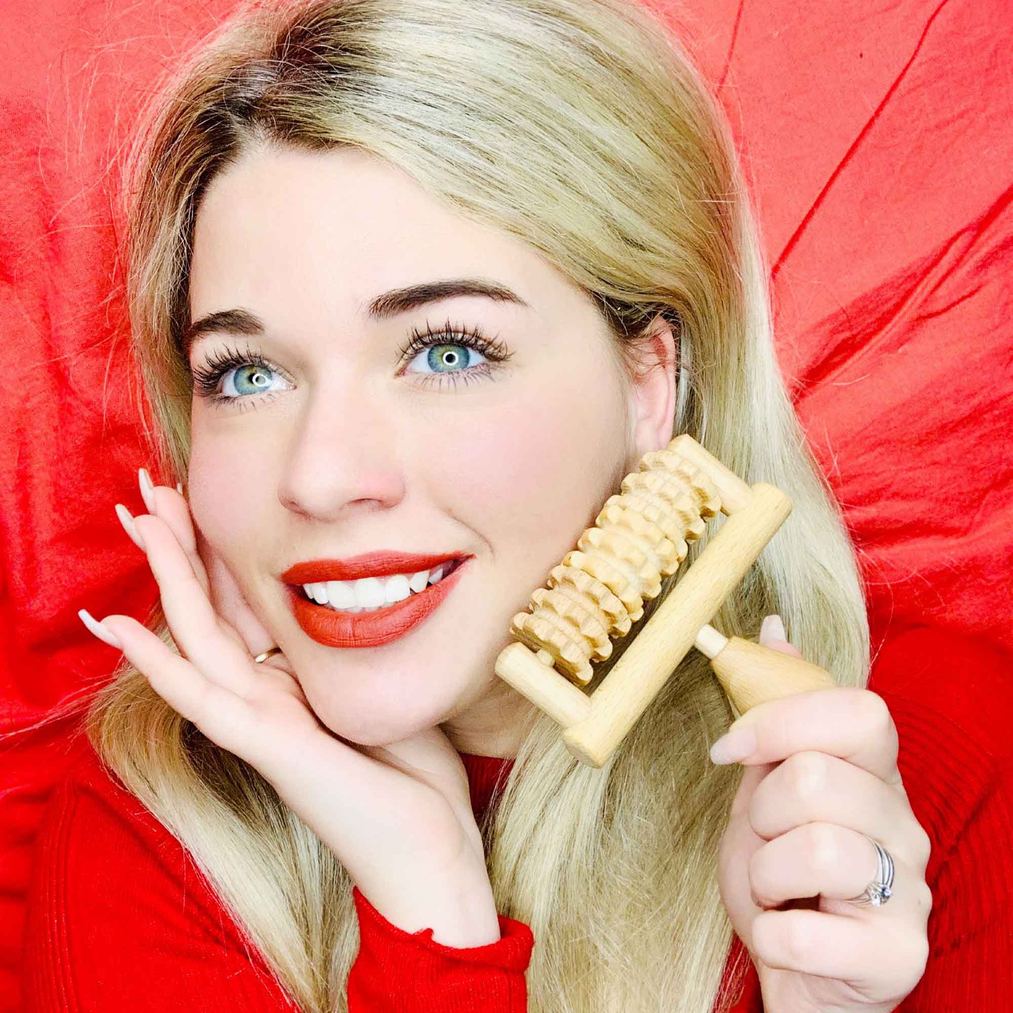 Wooden face massager held near the cheek for a simple self-care routine