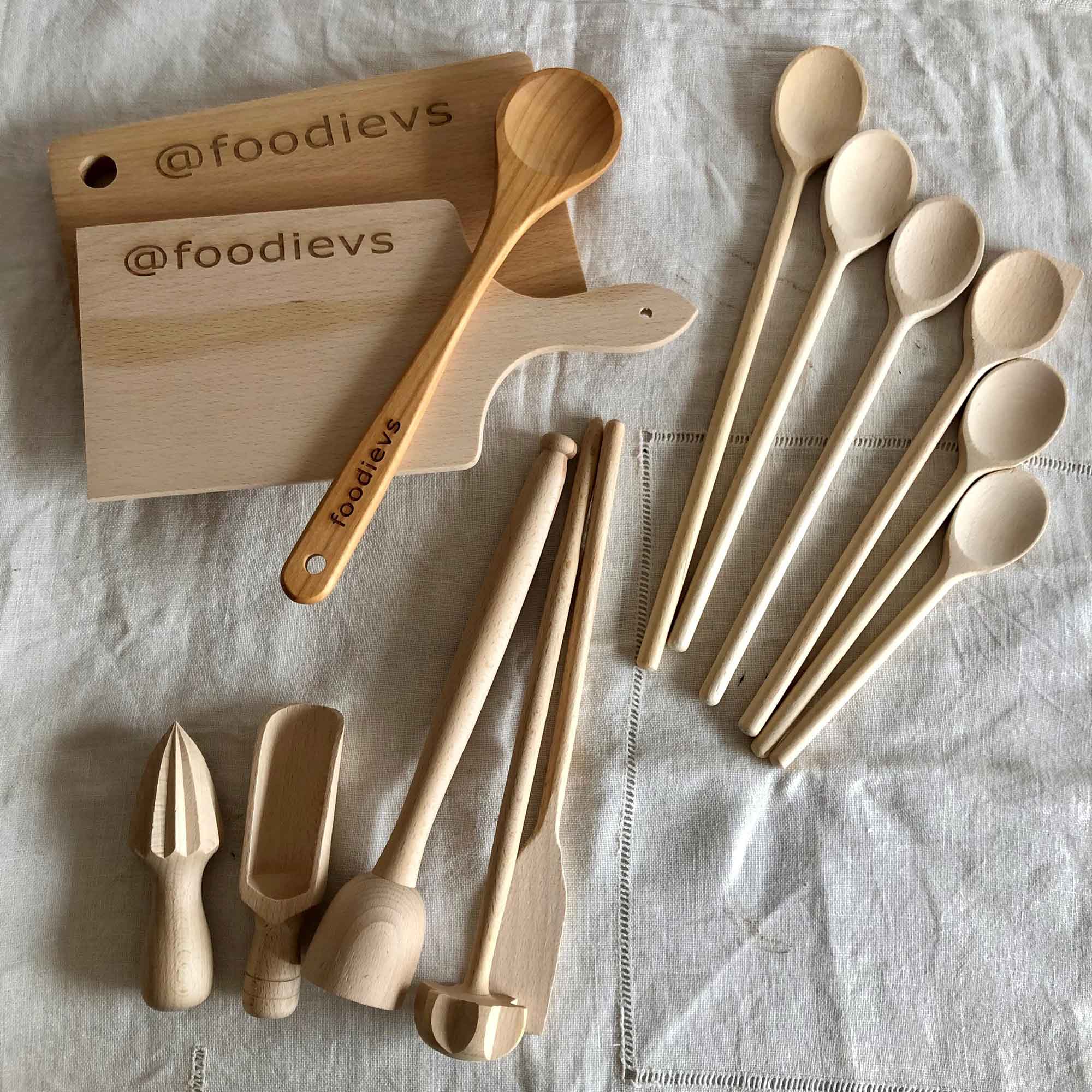 Wooden spoons, kitchen utensils and personalized boards arranged on a linen cloth