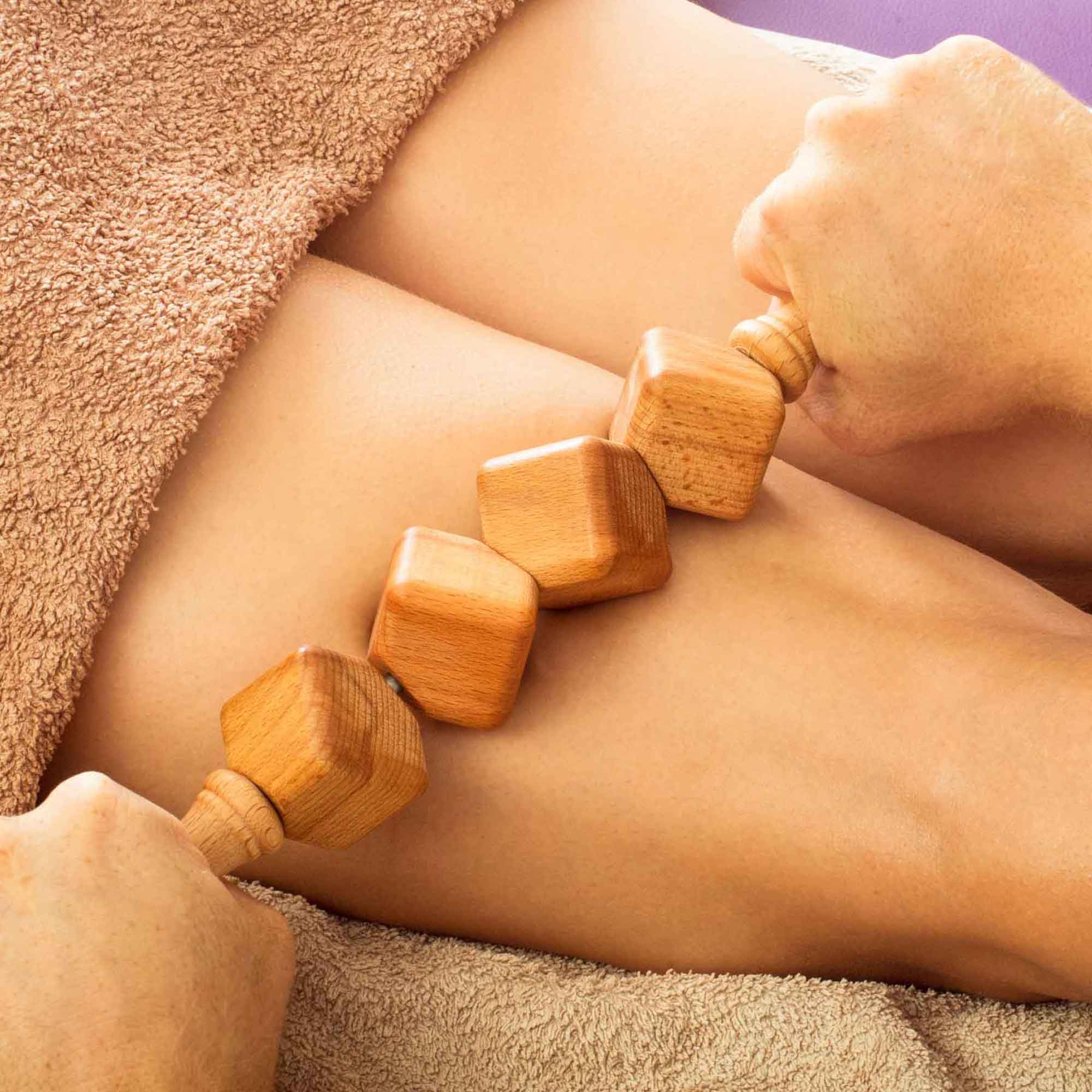 Wooden massage roller used as part of a gentle self-care routine