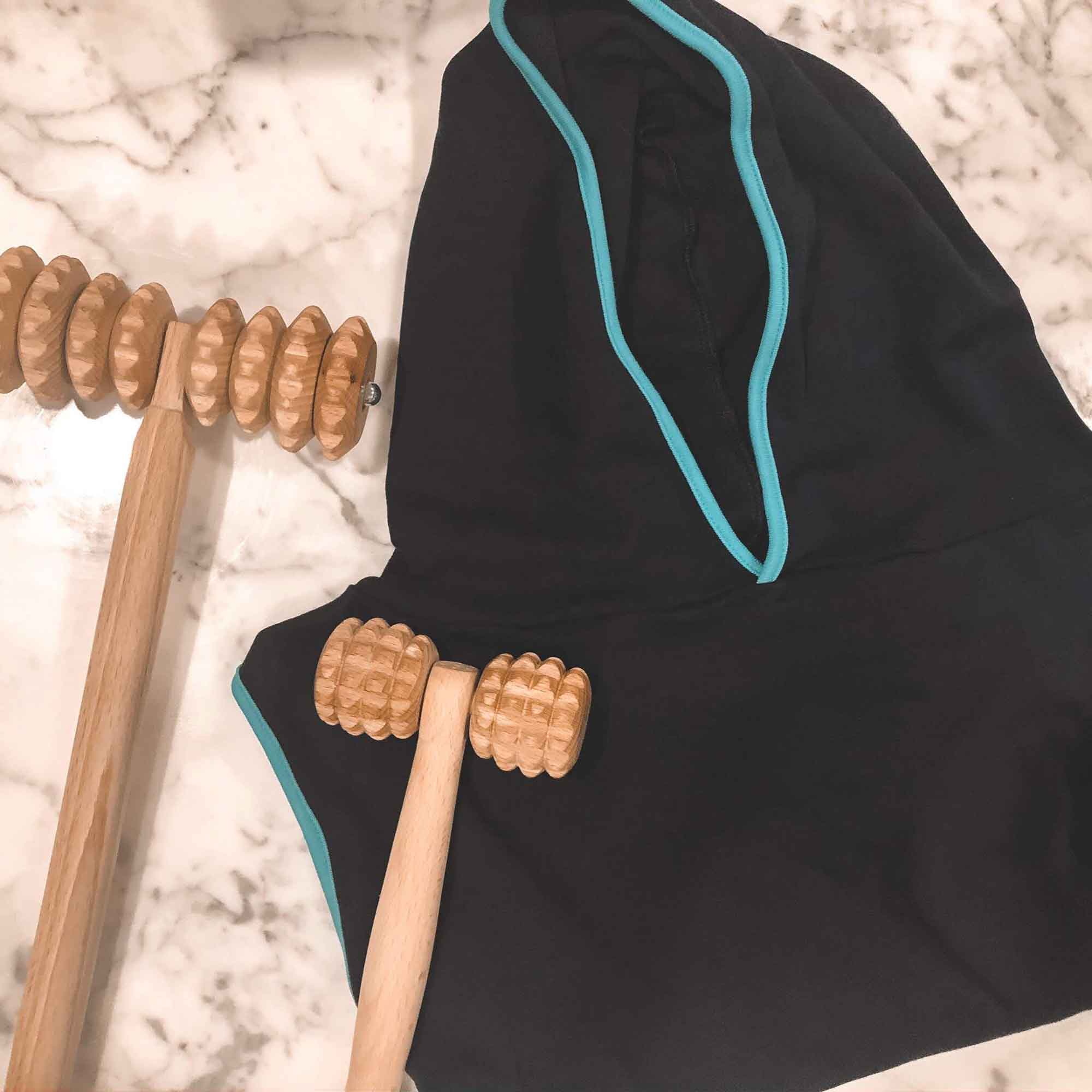 Wooden massage tools arranged with activewear for a home self-care routine