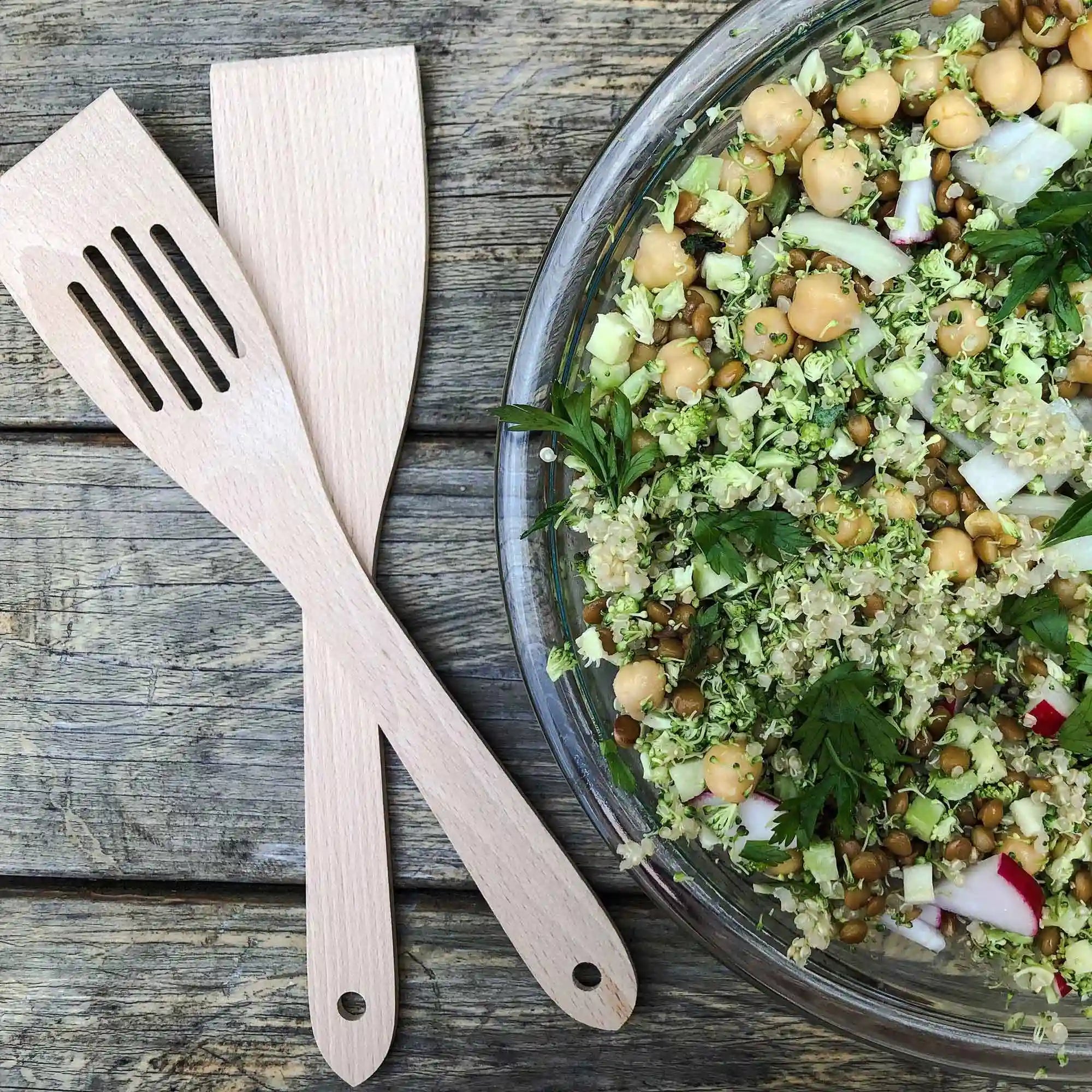Wooden spatulas beside a salad bowl for everyday kitchen use