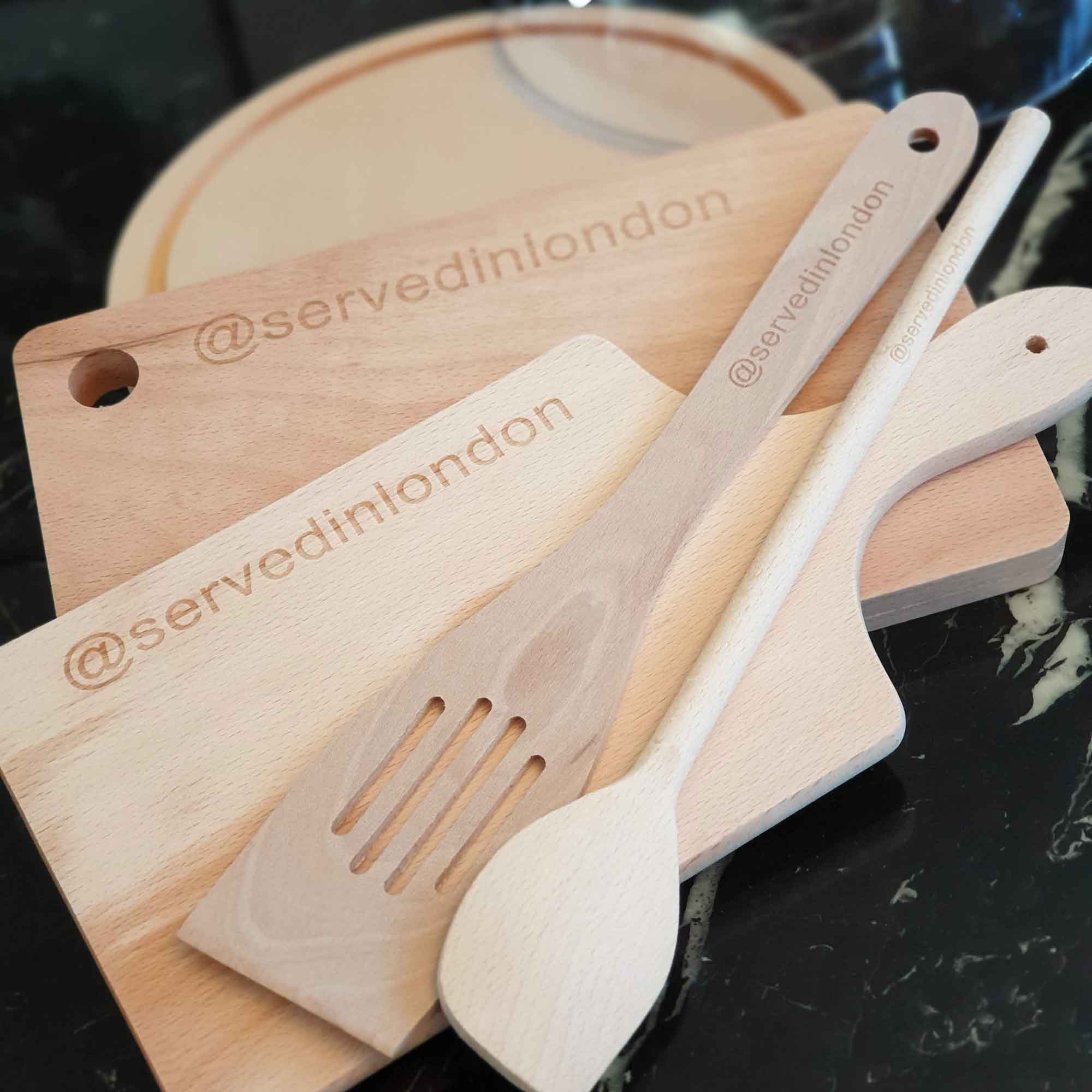 Wooden spoons and kitchen utensils arranged on a wooden cutting board