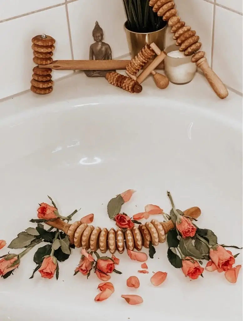 Tuuli wooden massager set arranged by a bathtub with roses