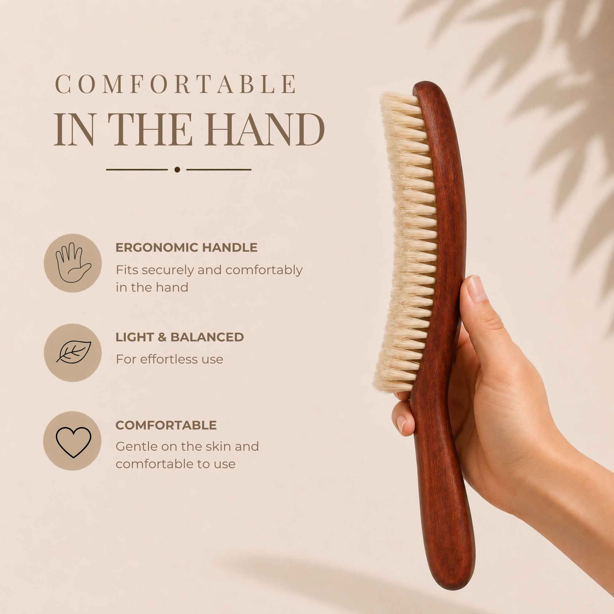 Hand holding a pear wood clothing brush upright beside comfort feature icons