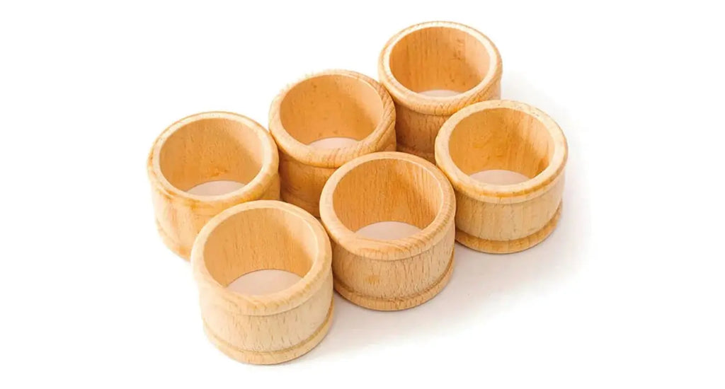 Rustiikkiset puiset servettirenkaat, jotka pitävät pellavakankaisia servettejä tyylikkäässä maatilapöydän kattauksessa