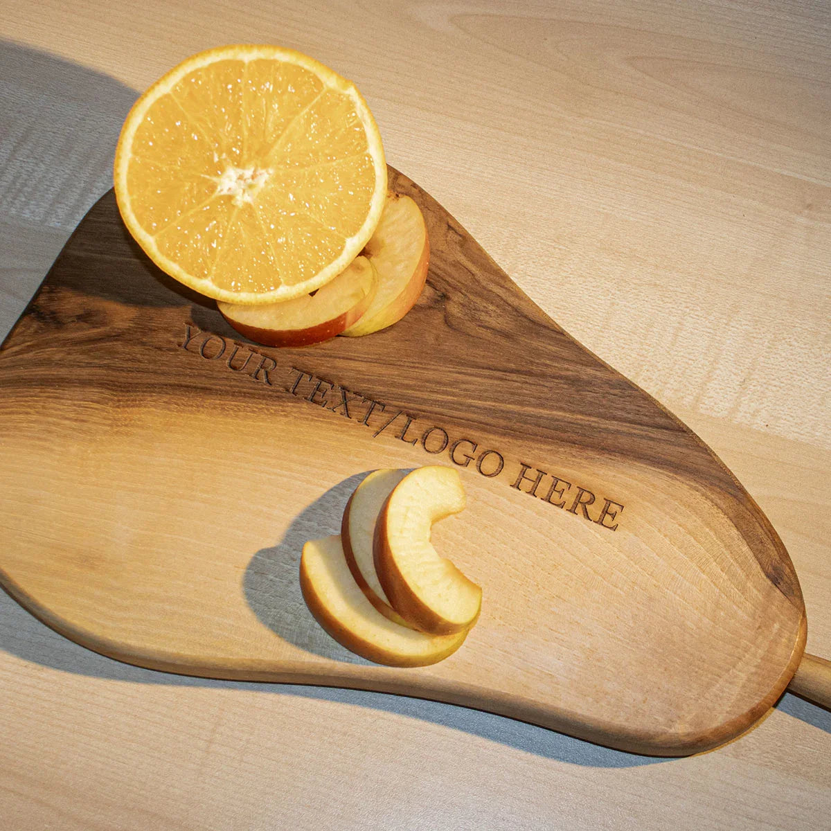Side view of sustainable walnut cutting board displaying thickness and pear-shaped design