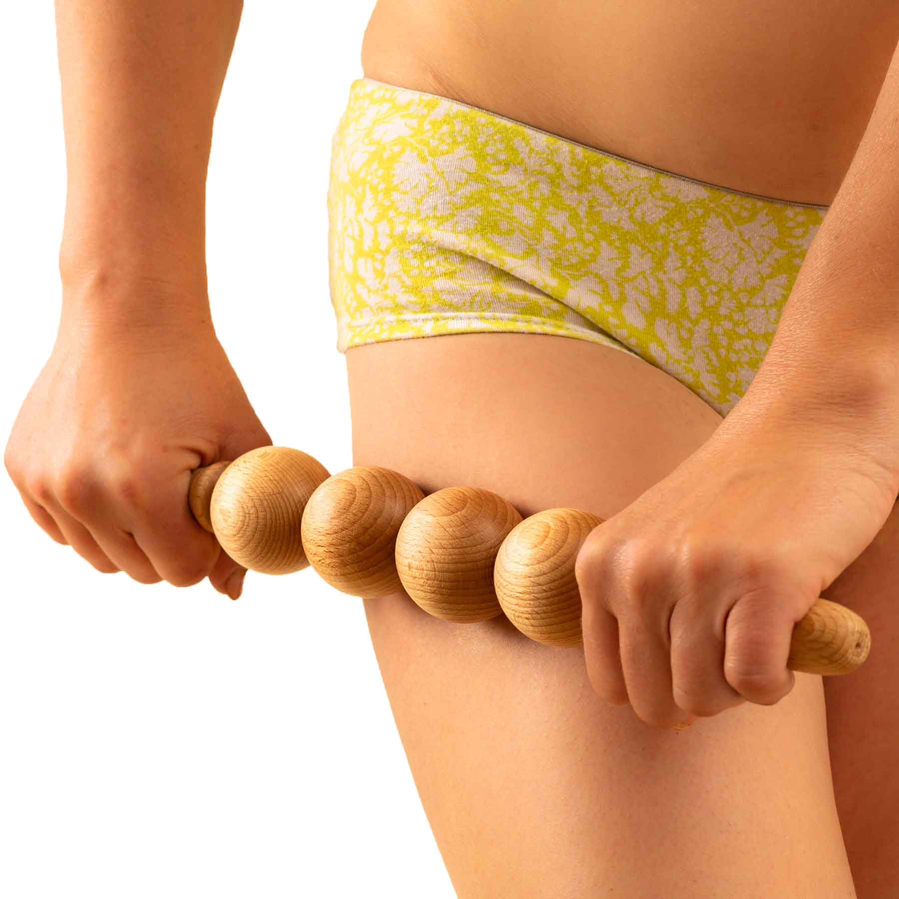 Person using a wooden massage roller on their leg against a white background